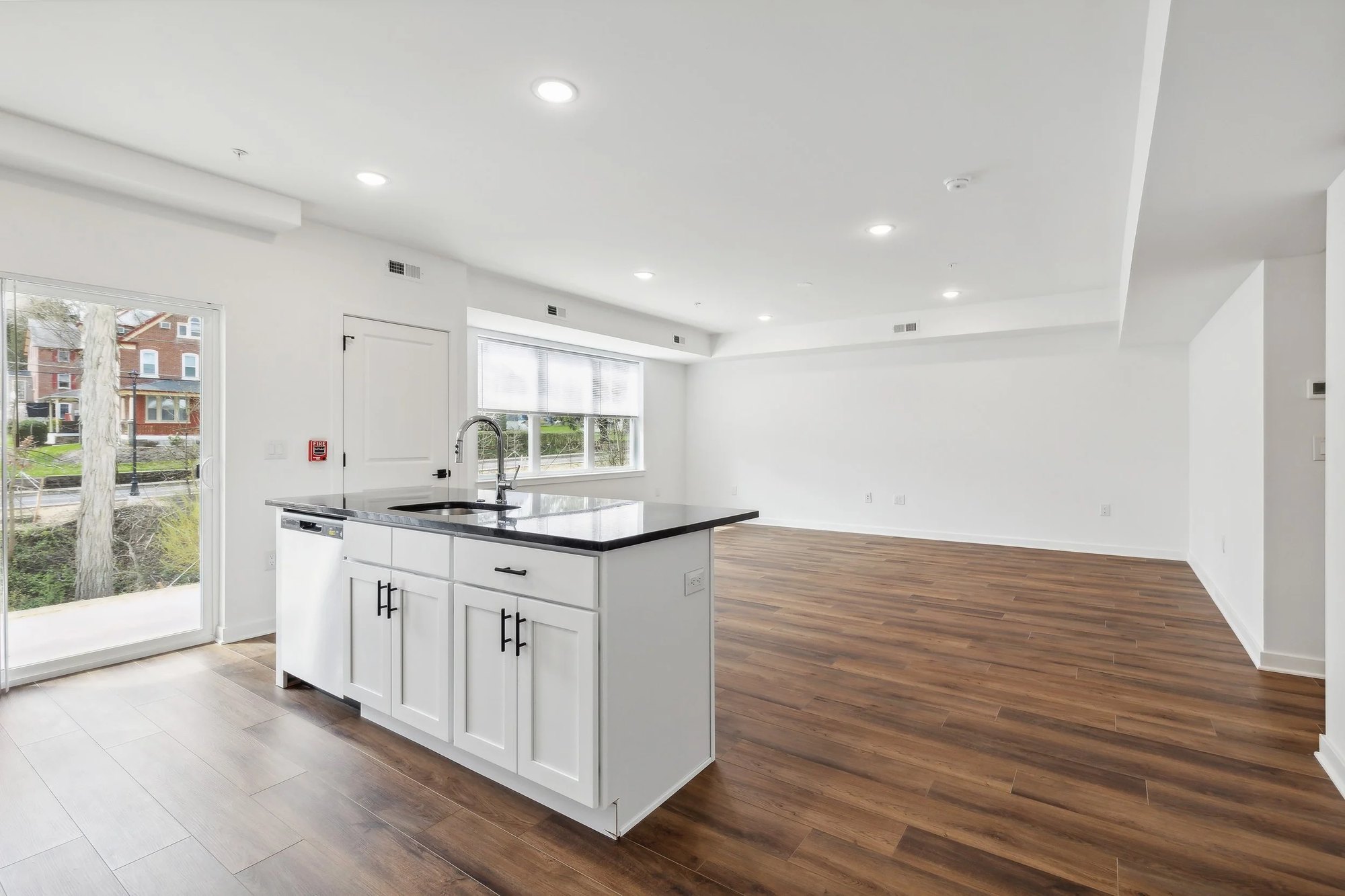 Kitchen island with white shaker cabinets and dark countertops