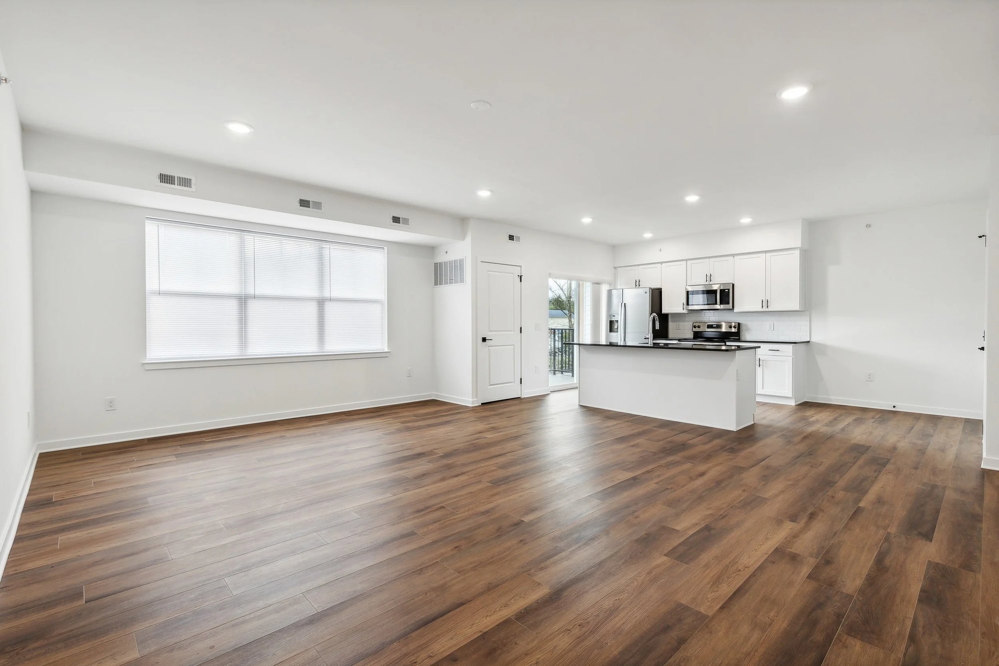 Open living space looking toward the kitchen with luxury vinyl plank flooring