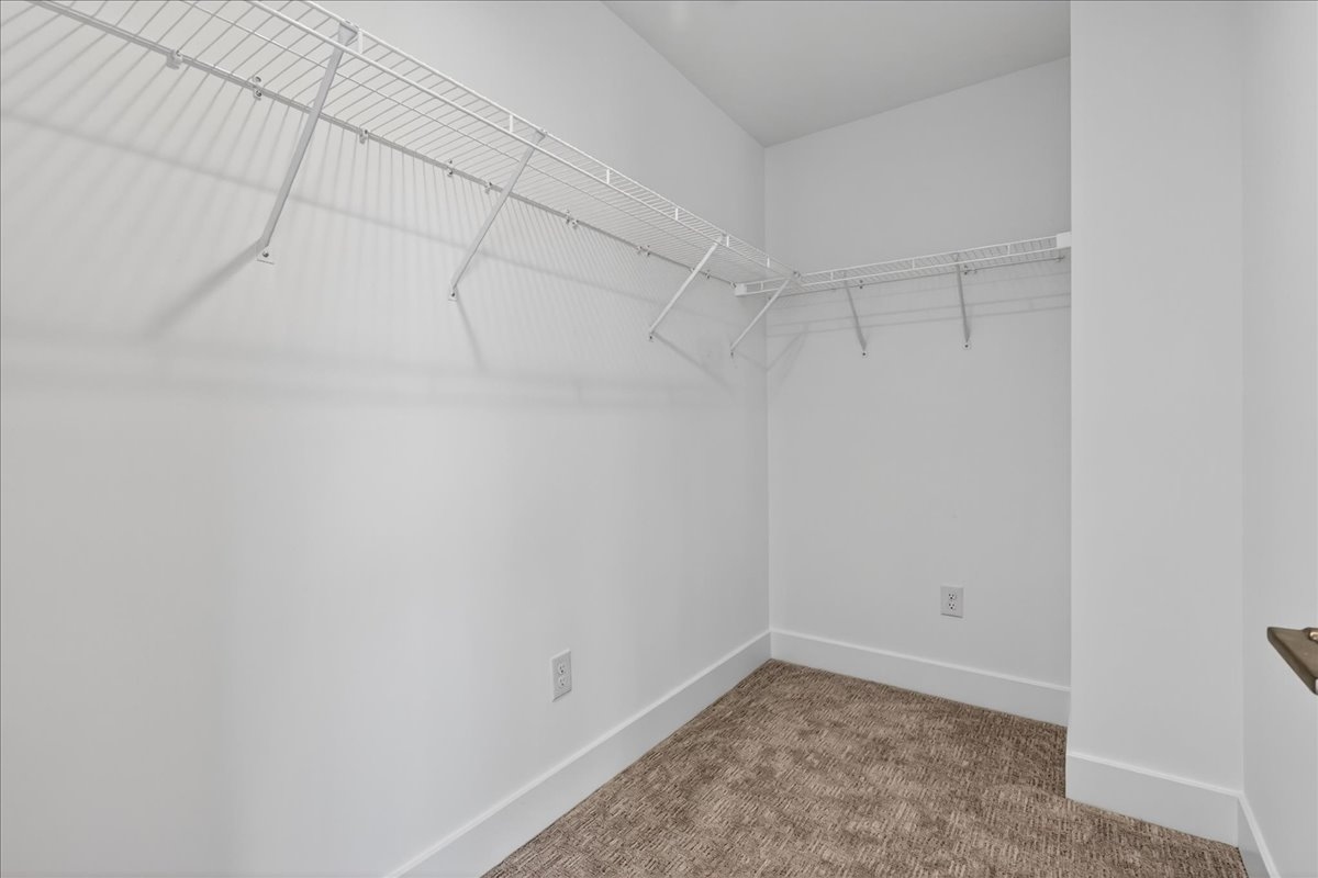 Primary walk-in closet with two levels of wire shelving on multiple walls
